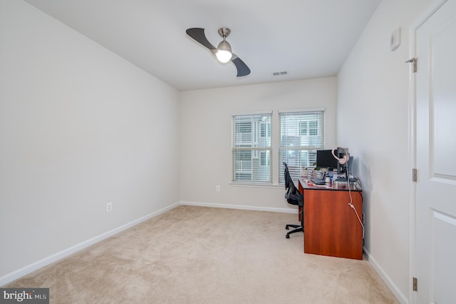 carpeted home office featuring ceiling fan