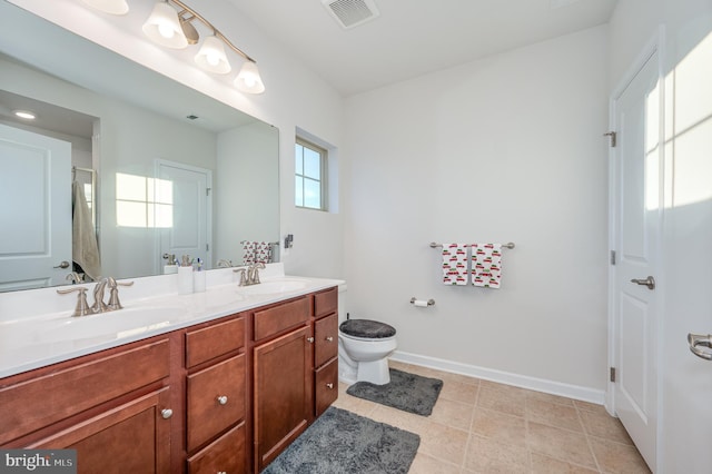 bathroom with tile patterned flooring, vanity, and toilet