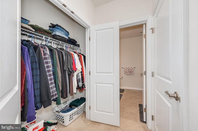 walk in closet with light carpet