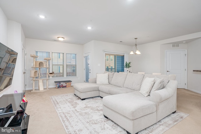 living room with carpet flooring and an inviting chandelier