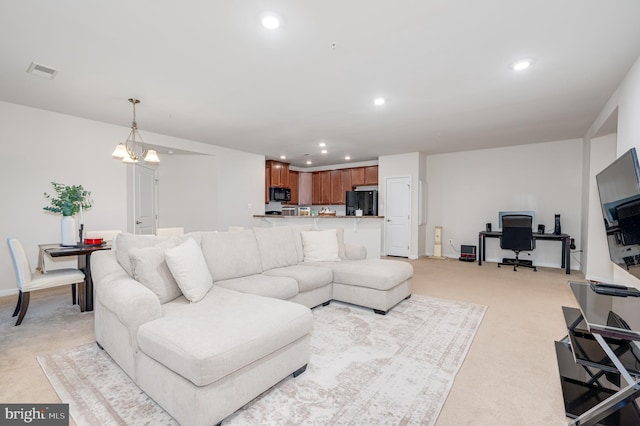 carpeted living room with a notable chandelier