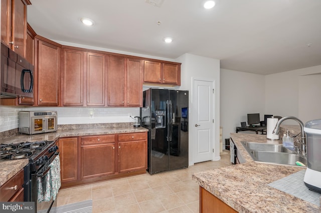 kitchen with backsplash, light stone counters, sink, and black appliances