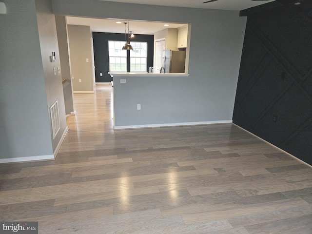 interior space featuring a barn door, ceiling fan, and light wood-type flooring