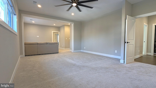 unfurnished living room featuring ceiling fan and light colored carpet