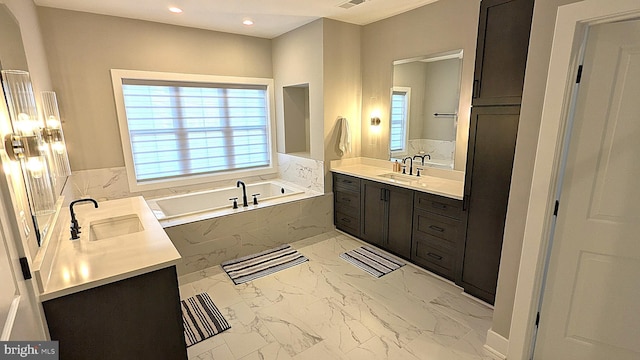 bathroom featuring vanity and a relaxing tiled tub