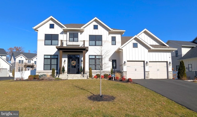 view of front of house with a balcony, a front yard, and a garage