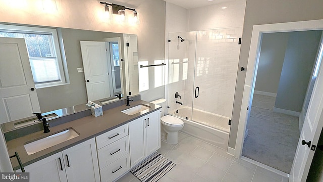 full bathroom with shower / bath combination with glass door, tile patterned floors, vanity, and toilet