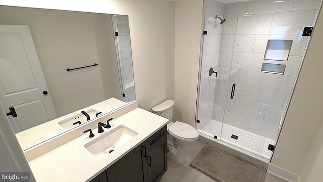 bathroom featuring tile patterned floors, vanity, an enclosed shower, and toilet