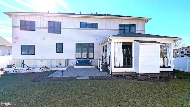 back of property featuring a lawn, an outdoor living space, and a patio