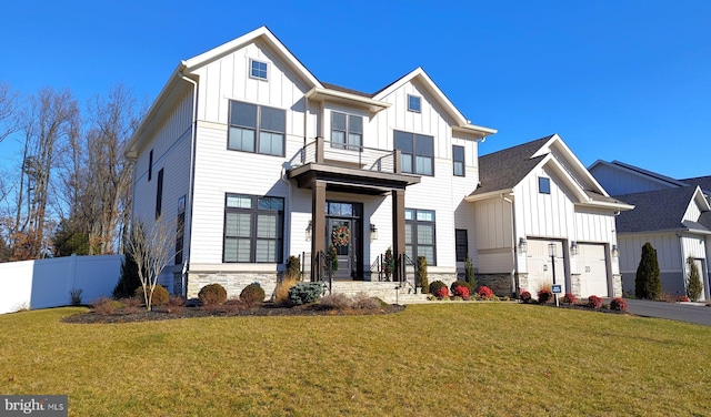 view of front of property with a balcony, a front lawn, and a garage