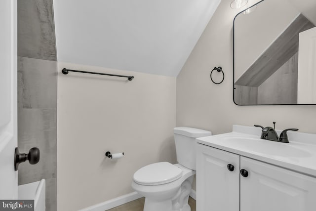 bathroom with vanity, toilet, and vaulted ceiling