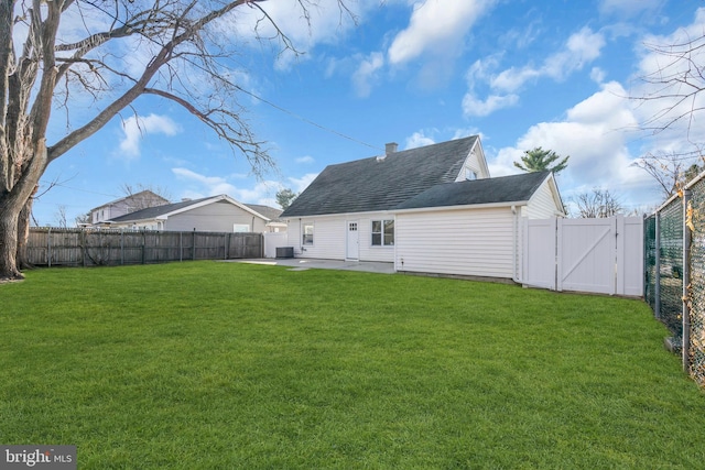 rear view of property with a lawn, a patio area, and central AC