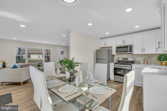 dining area with light hardwood / wood-style floors and sink