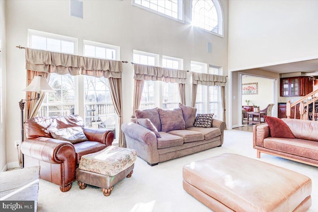 carpeted living room with a towering ceiling and a wealth of natural light