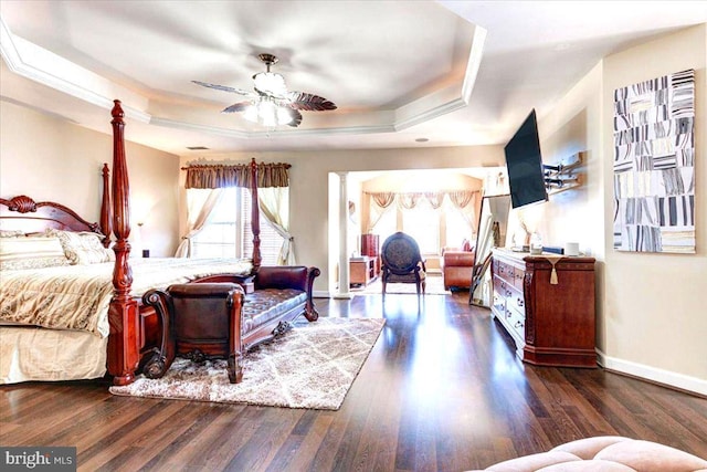 bedroom featuring dark hardwood / wood-style flooring, a tray ceiling, ceiling fan, and crown molding