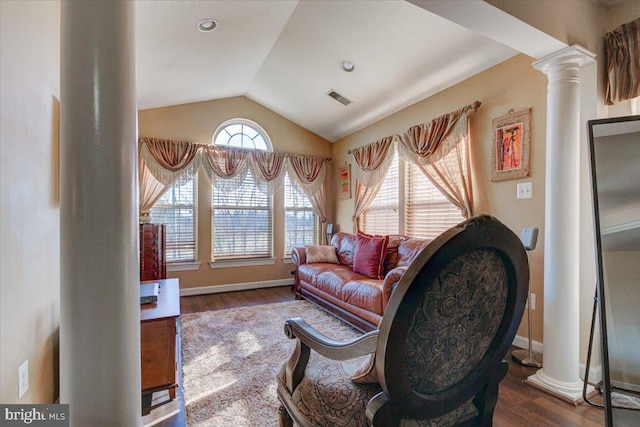 living area with hardwood / wood-style floors, decorative columns, and a wealth of natural light