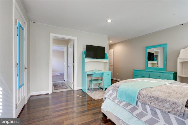 bedroom featuring ensuite bathroom and dark hardwood / wood-style flooring