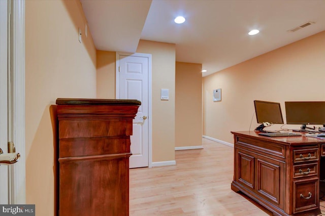 home office with light hardwood / wood-style floors