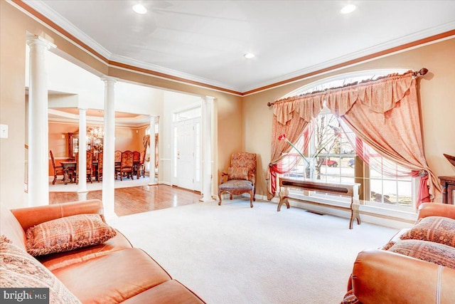 living area with carpet, decorative columns, and ornamental molding