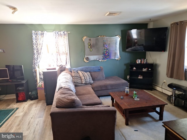 living room featuring a baseboard heating unit and light wood-type flooring