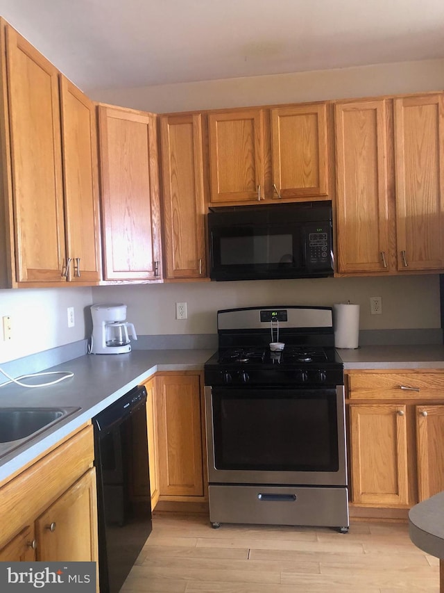 kitchen with sink, light wood-type flooring, and black appliances