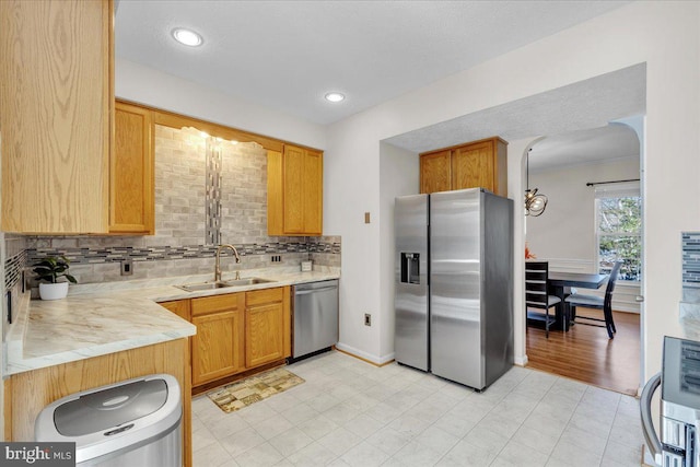 kitchen featuring appliances with stainless steel finishes, backsplash, and sink