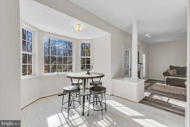 tiled dining area featuring decorative columns