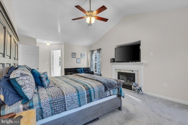 bedroom with ceiling fan, light colored carpet, lofted ceiling, and a premium fireplace