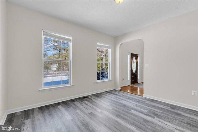 empty room featuring hardwood / wood-style flooring and a textured ceiling