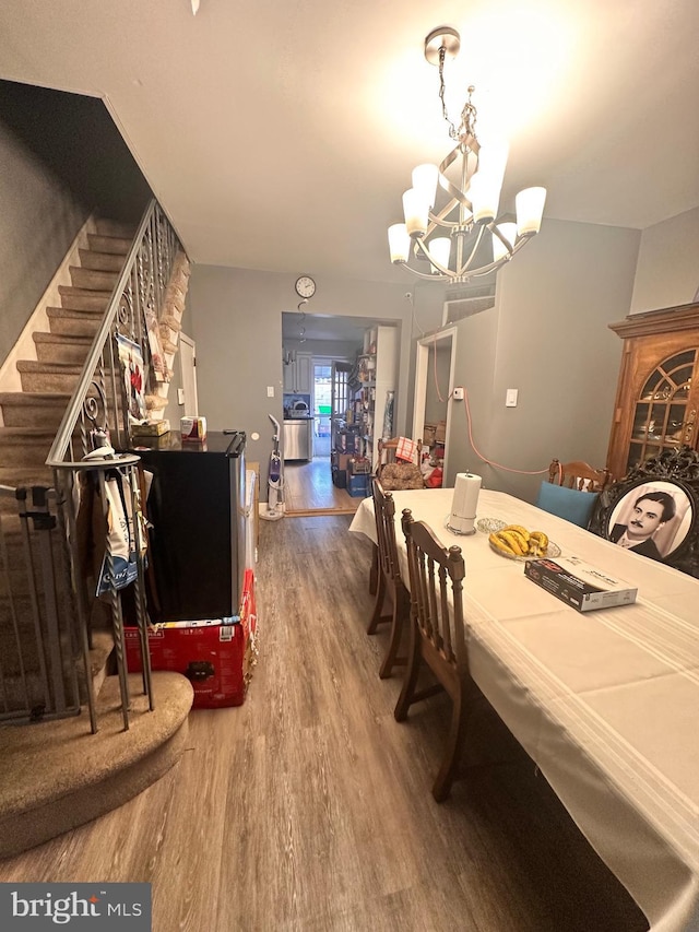 dining area featuring hardwood / wood-style floors and a notable chandelier