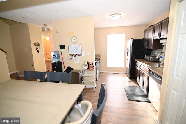 kitchen featuring dishwasher, sink, tasteful backsplash, light hardwood / wood-style floors, and dark brown cabinets