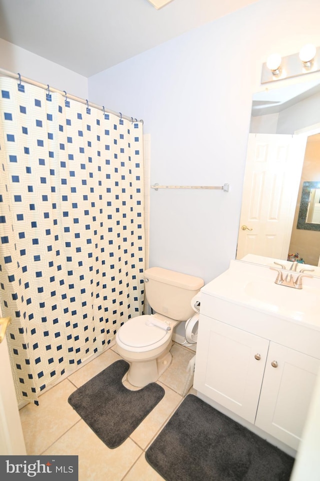 bathroom with tile patterned floors, curtained shower, vanity, and toilet