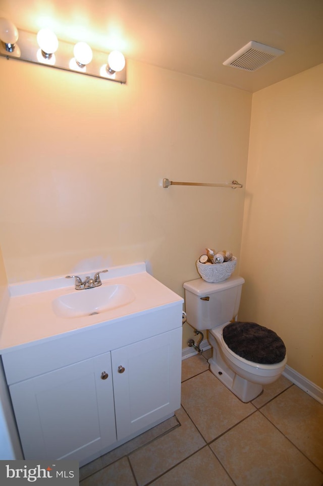 bathroom featuring tile patterned flooring, vanity, and toilet