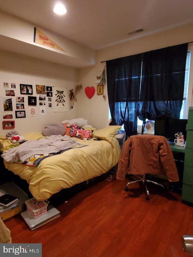 bedroom featuring hardwood / wood-style floors and fridge