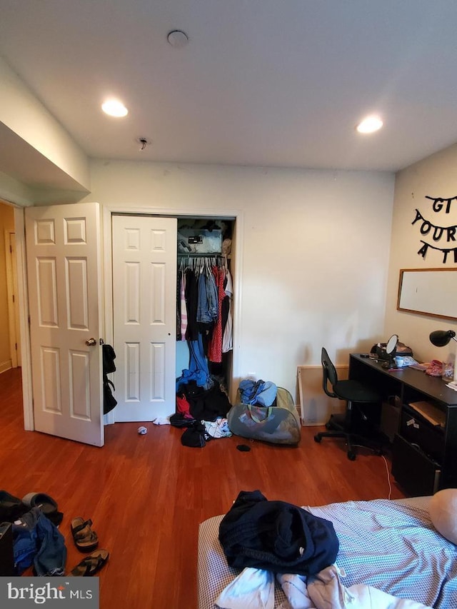 bedroom with wood-type flooring and a closet