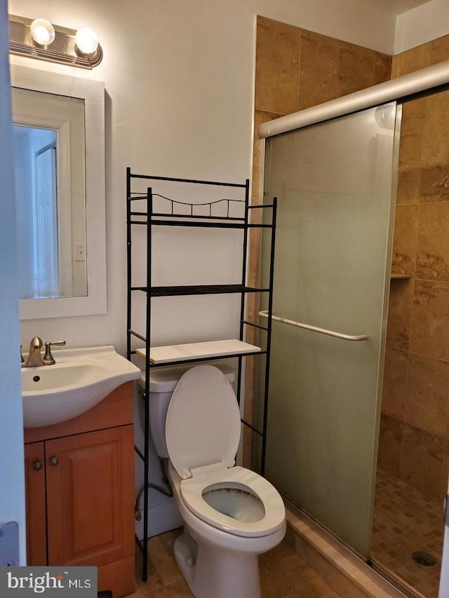 bathroom with vanity, toilet, and a shower with shower door