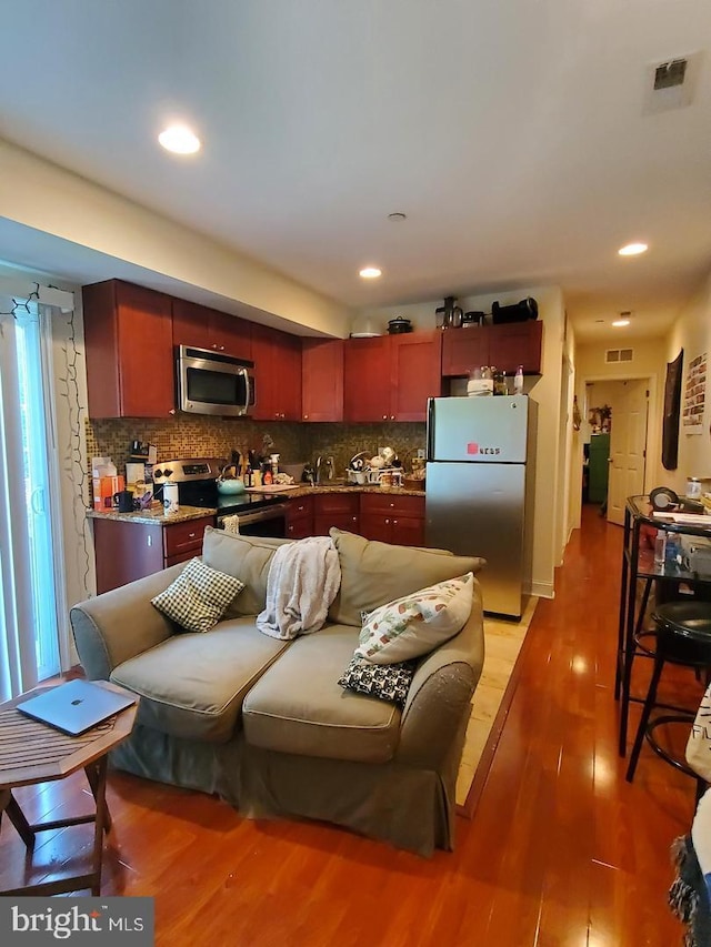 kitchen featuring hardwood / wood-style floors, backsplash, and stainless steel appliances