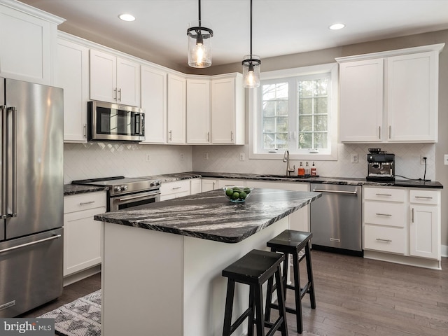 kitchen with white cabinets, stainless steel appliances, and a kitchen island