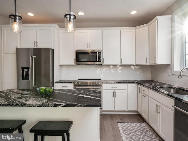 kitchen with decorative light fixtures, white cabinetry, and appliances with stainless steel finishes