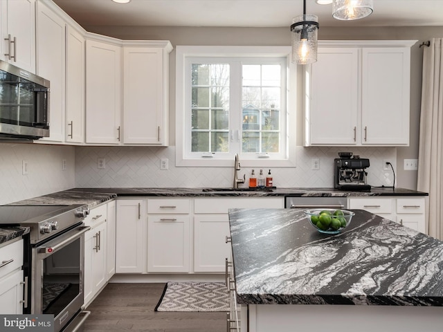 kitchen featuring white cabinets, decorative light fixtures, sink, and stainless steel appliances