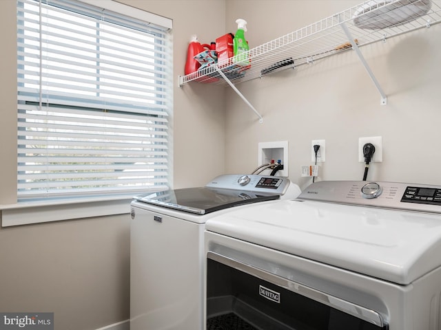 laundry room with washing machine and dryer and a healthy amount of sunlight