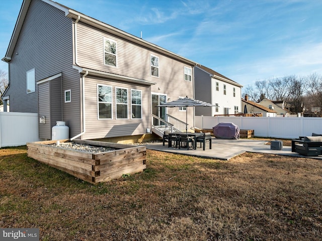 rear view of property featuring a yard and a patio area