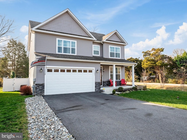 view of front of house with covered porch, a garage, and a front lawn