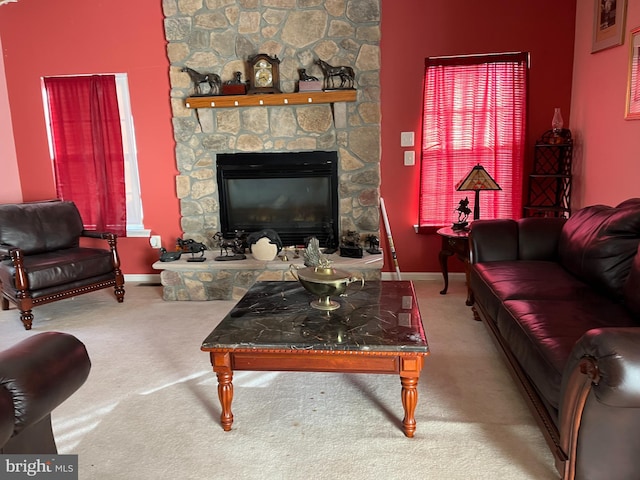 living room featuring carpet flooring and a stone fireplace