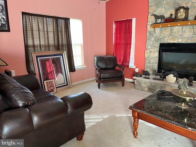 living room with light carpet and a stone fireplace