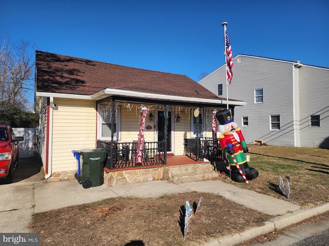 bungalow featuring a porch and a front lawn