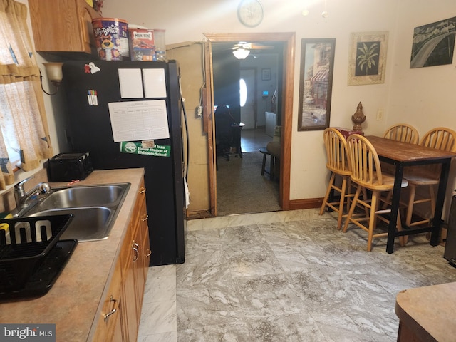 kitchen featuring refrigerator, ceiling fan, and sink