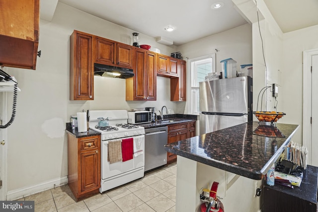 kitchen featuring a breakfast bar, sink, light tile patterned flooring, kitchen peninsula, and stainless steel appliances