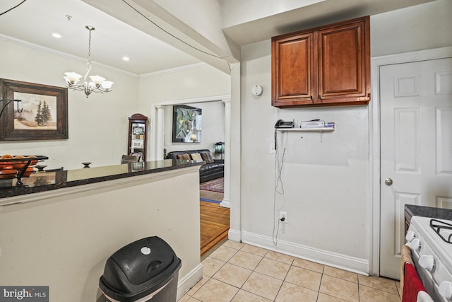 kitchen featuring white range with electric cooktop, crown molding, decorative light fixtures, light tile patterned floors, and a notable chandelier