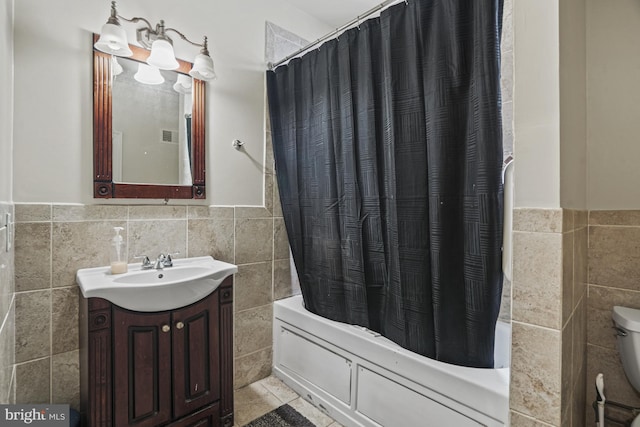 bathroom featuring vanity, shower / bath combination with curtain, and tile walls